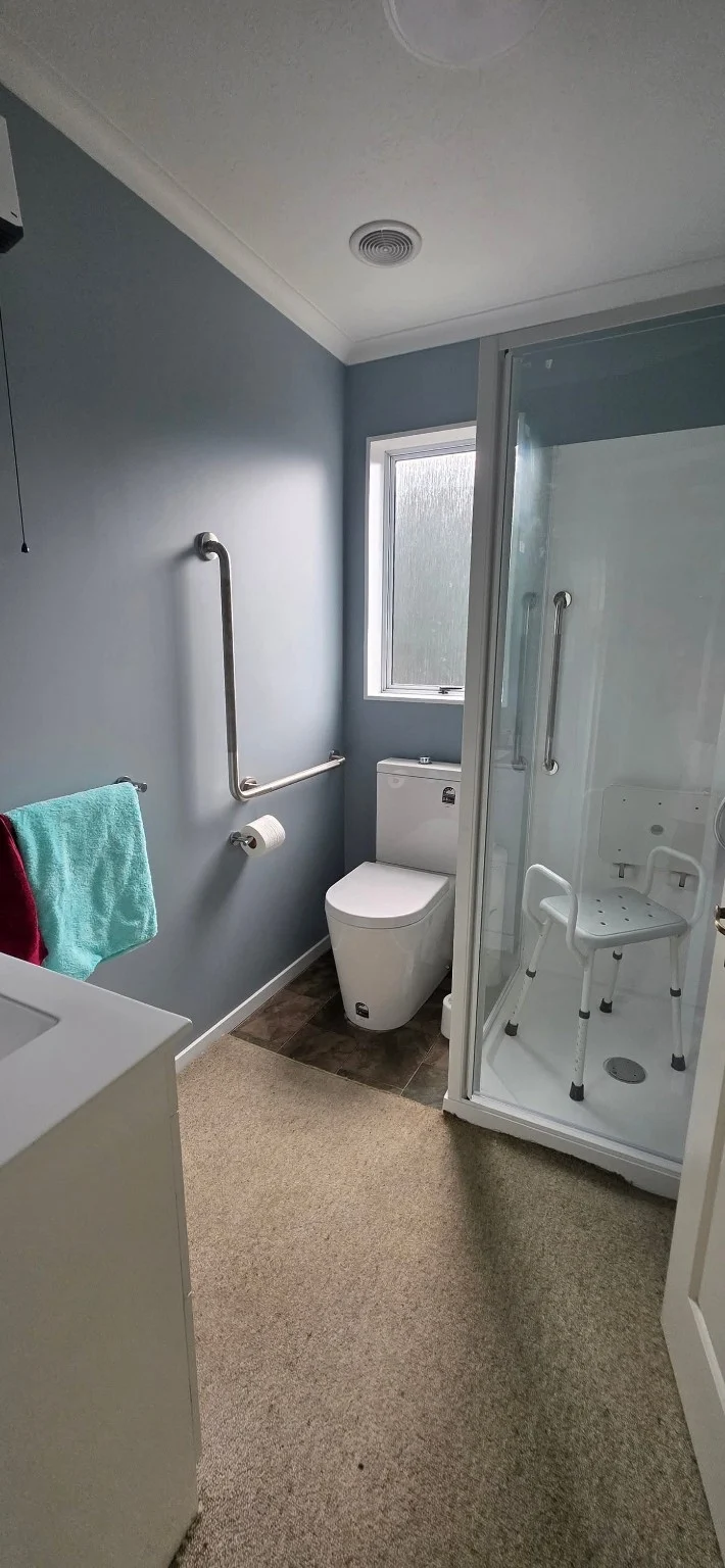 Blue-grey painted bathroom with white trim and shower