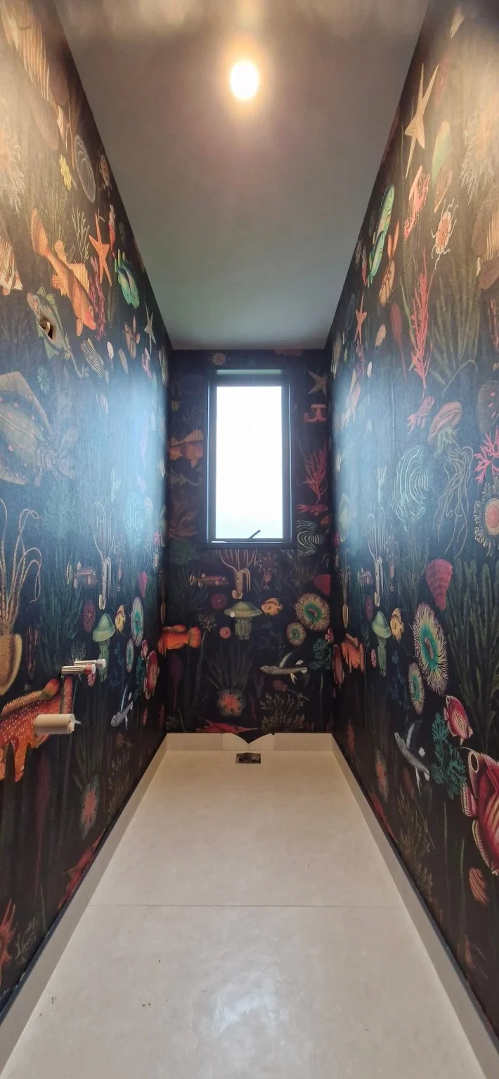 Marine-life wallpaper surrounding a narrow room